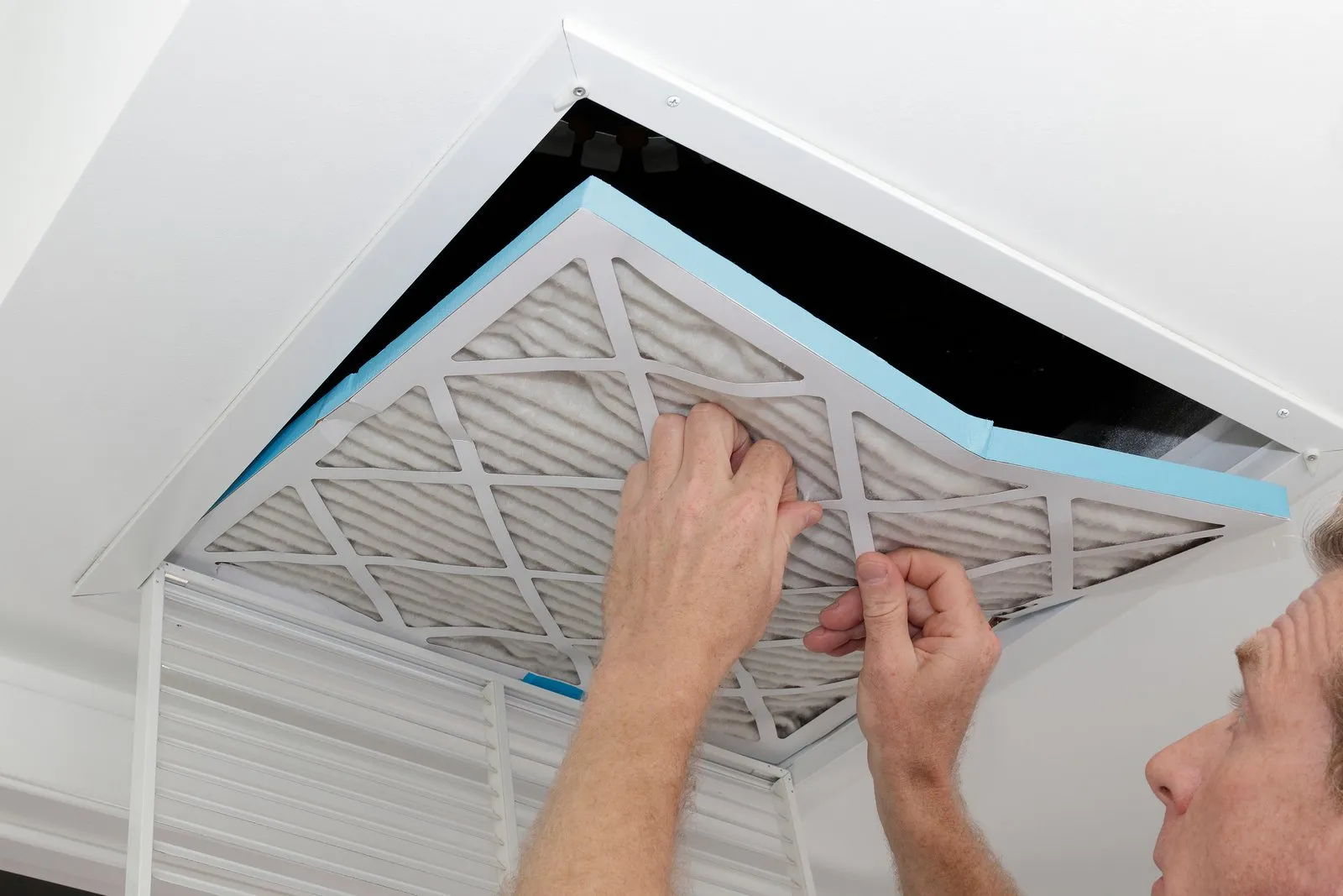 Technician cleaning an air duct vent in a Riviera Beach home